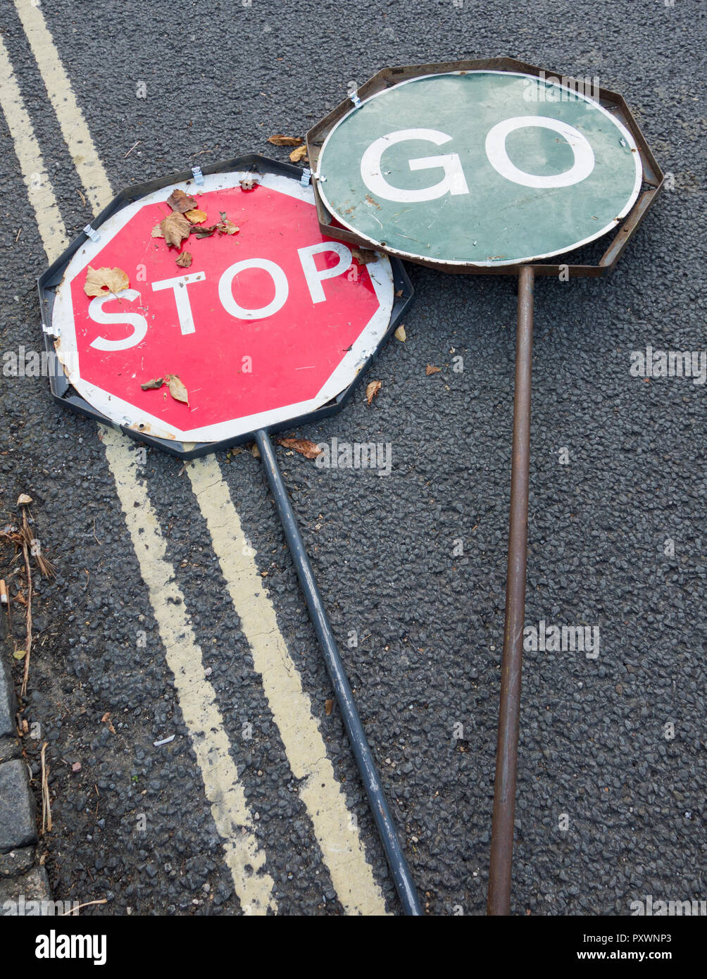Stop-Go-Verkehrszeichen werden in Großbritannien auf einer Straße weggeworfen Stockfoto