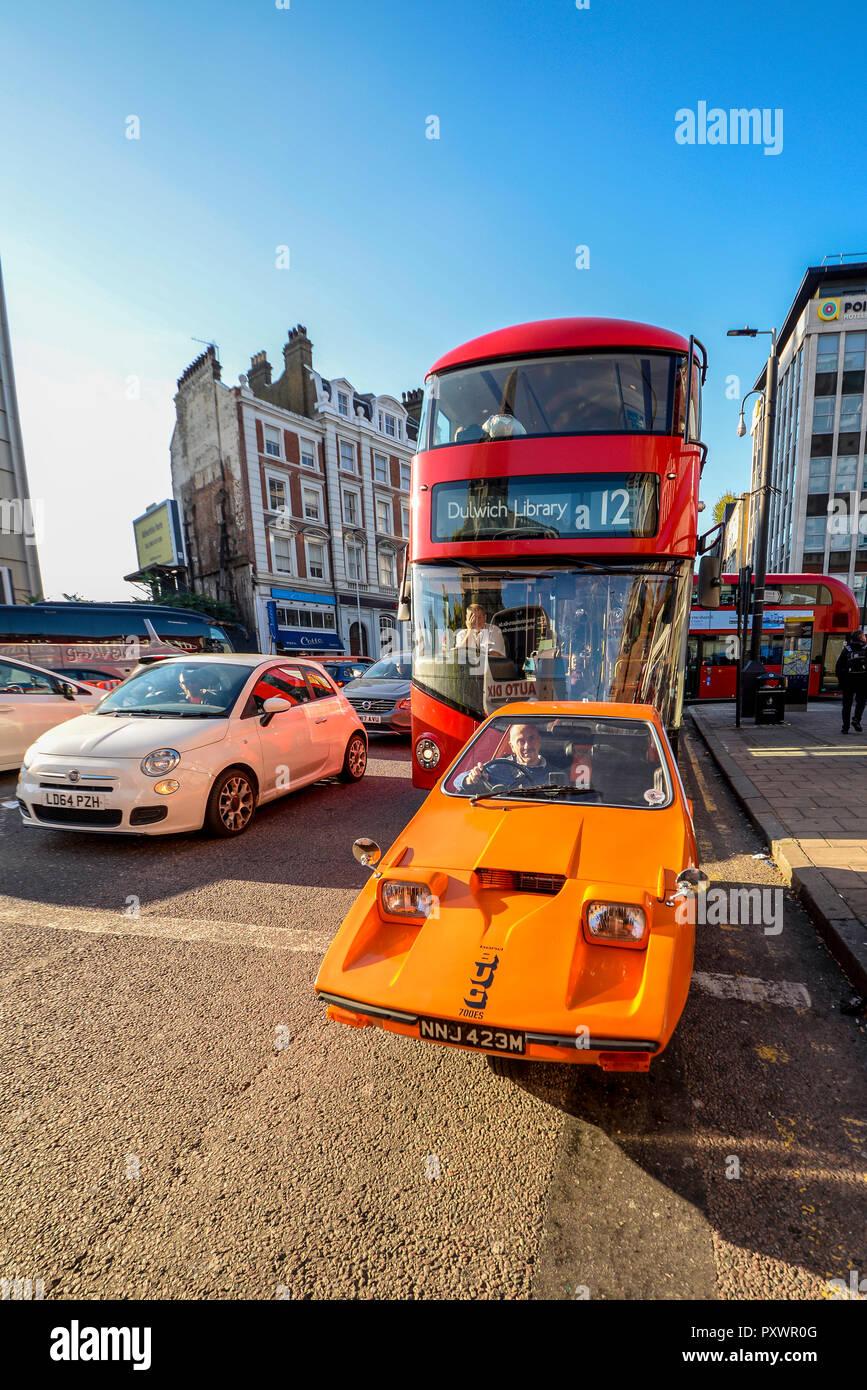 Bond Bug dreirädrigen Auto in London Verkehr mit Red London Bus hinter sich. London Verkehr. Microcar. 70er-Jahre Design. Stockfoto