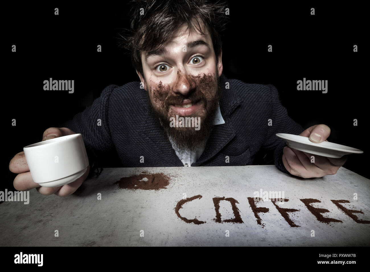 Bärtiger Mann mit Kaffee, wütend in die Kamera schaut, das Konzept der Kaffee ist eine Droge Stockfoto