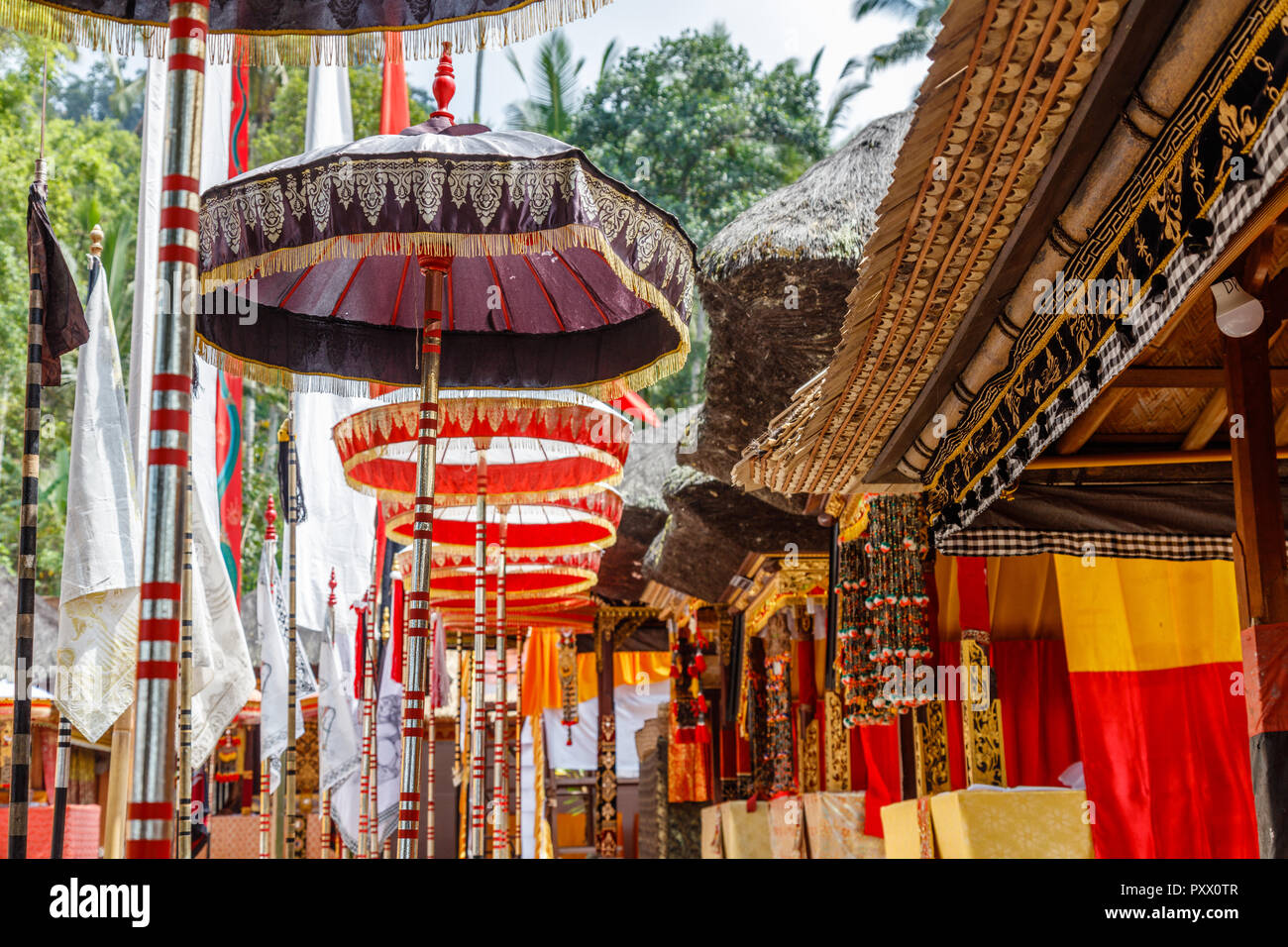 Bunte Sonnenschirme in der Nähe von heiligen Banyan Tree bei Pura Kehen, balinesischen Hindu Tempel in Bangli Regency, Bali, Indonesien für Melasti Feier gestaltet. Stockfoto