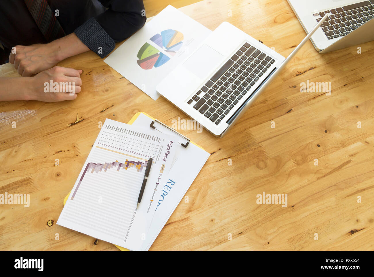 Geschäftsmann analysieren Daten aus Business Report Chart. Blick von oben auf die Holz-, Desktop mit labtop. Vintage tone Retro filter Effekt, Weichzeichner, niedrige li Stockfoto