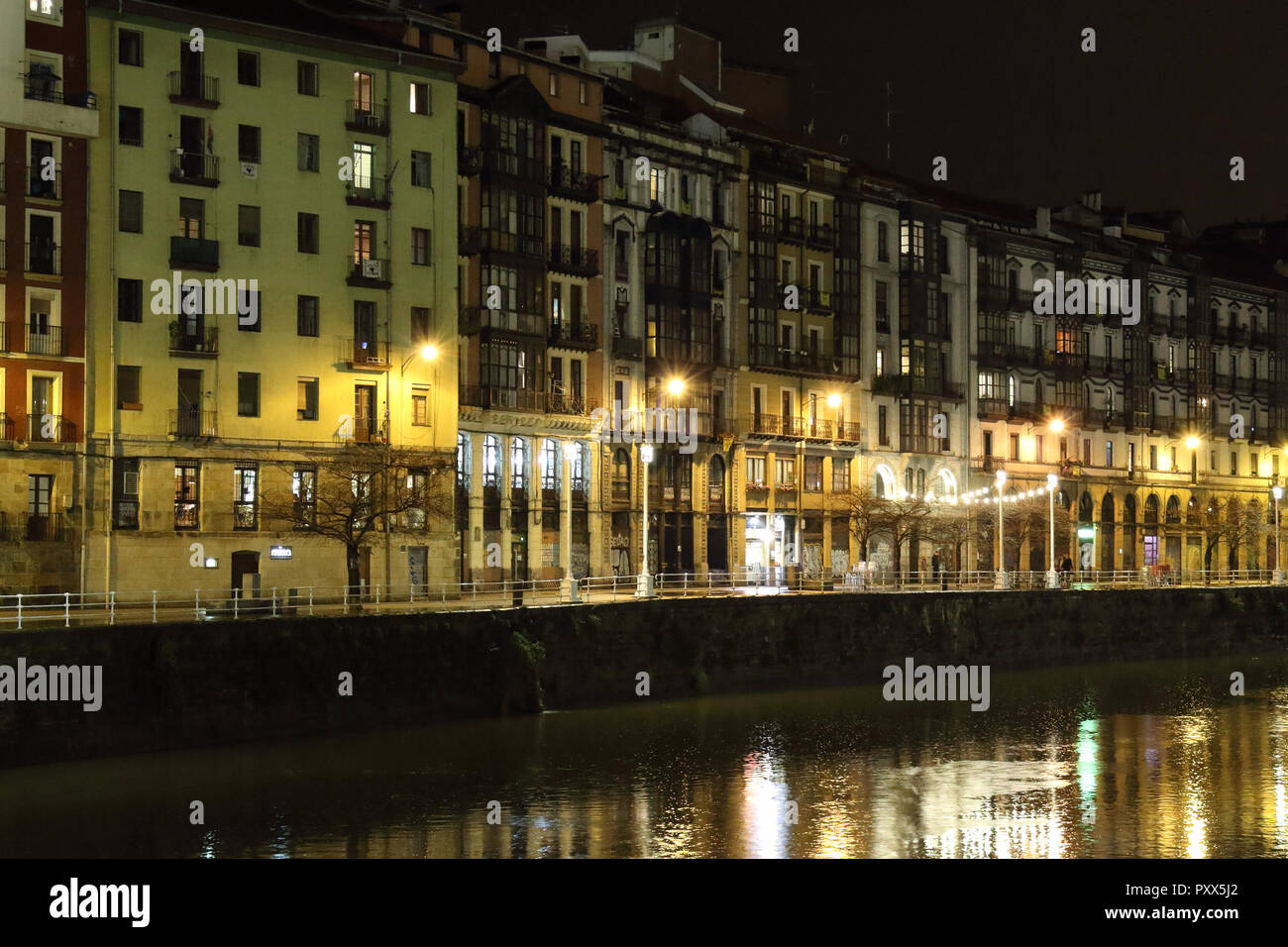 Die Ufer Gasse (Paseo de la Ribera) in Bilbao, Baskenland, Spanien, während eines Winters Nacht, mit typisch baskische Häuser mit gelben Lichter spiegeln Stockfoto