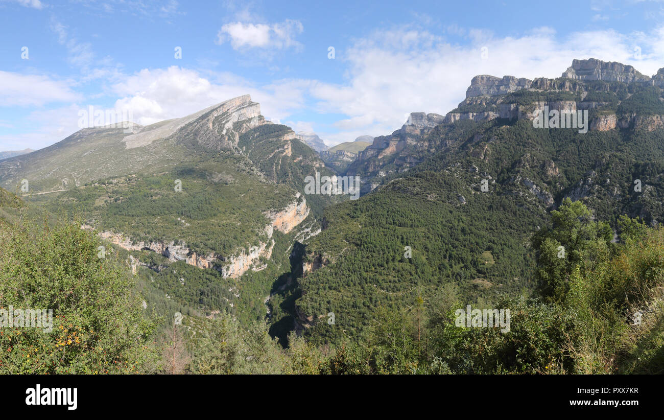 Eine Landschaft von den Eingang der Cañon de Añisclo Tal, mit hohen Bergen, grünen Wäldern und blauen Himmel, in den Pyrenäen, Aragon, Spanien Stockfoto