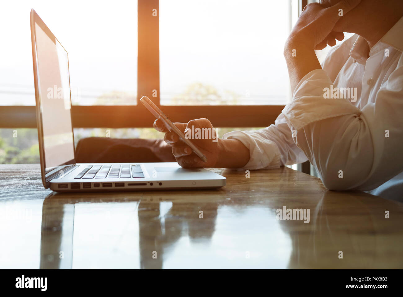 Nachdenklich Geschäftsmann oder erfahrener Unternehmer mit Smartphone und Laptop für analize Informationen Stockfoto