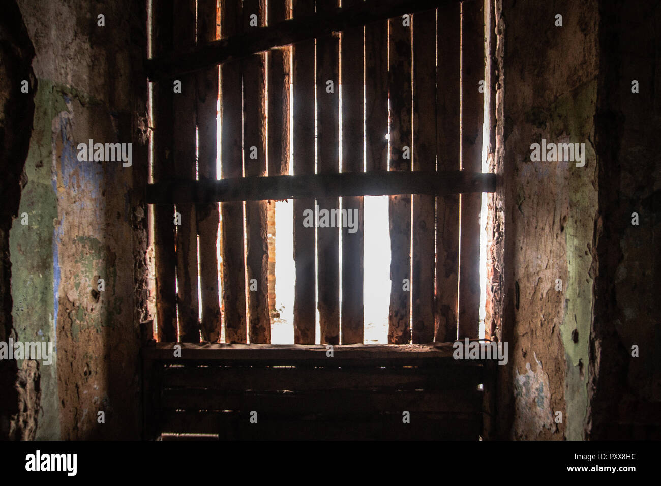 Das Sonnenlicht dringt durch die Zerschlagenen Fenster in der alten dunklen Zimmer. Stockfoto