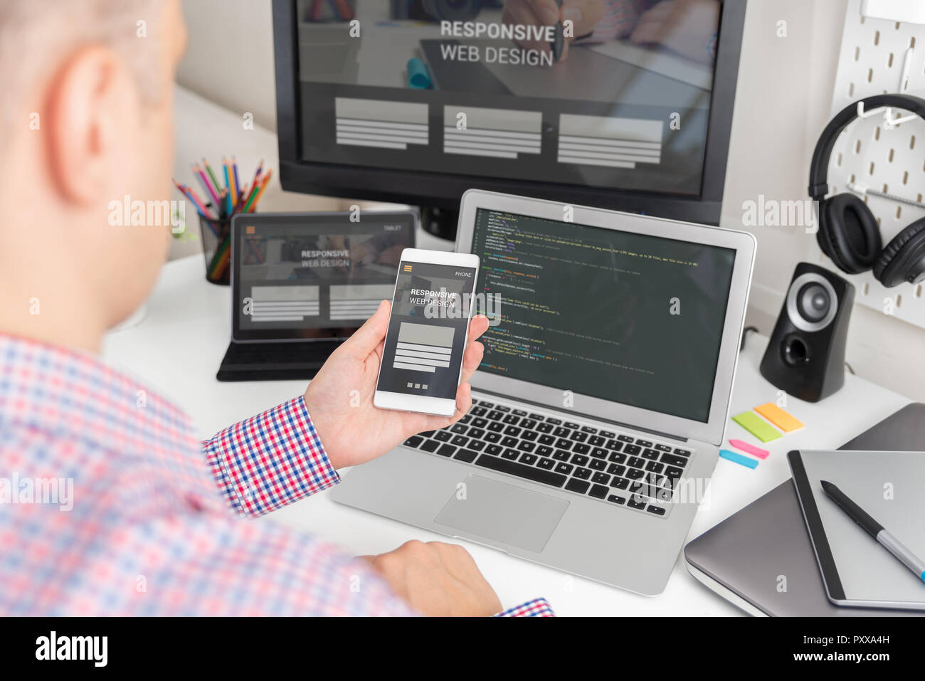 Designer arbeiten an Reaktionsschnelle web design Projekt. Web Entwickler und Programmierer arbeiten im Büro mit modernen Geräten auf dem Schreibtisch Stockfoto