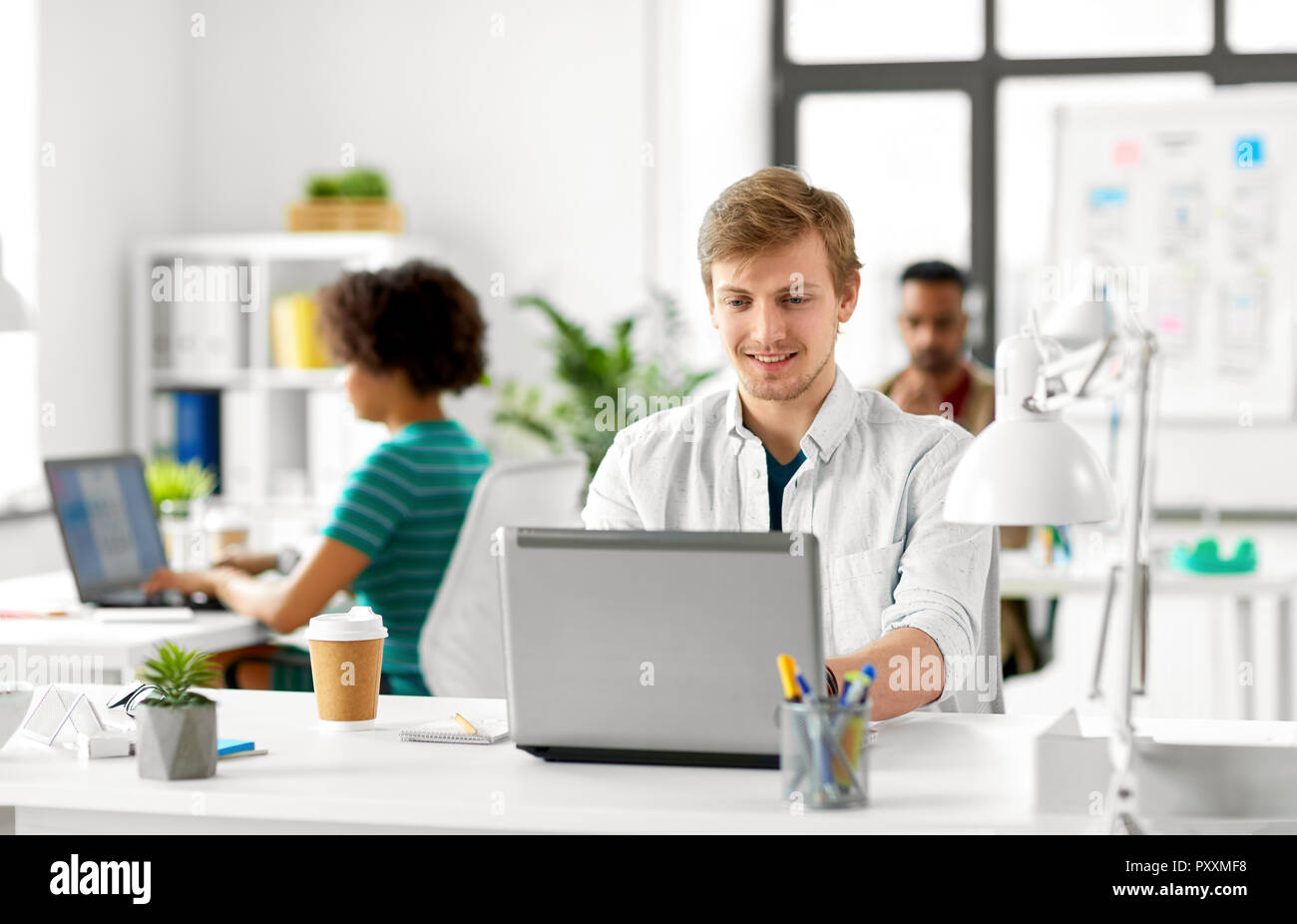 Kreative männliche Mitarbeiter mit Laptop Stockfoto