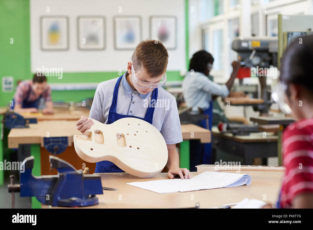 Männliche Schüler Gebäude Gitarre in Holzarbeiten Lektion Stockfoto