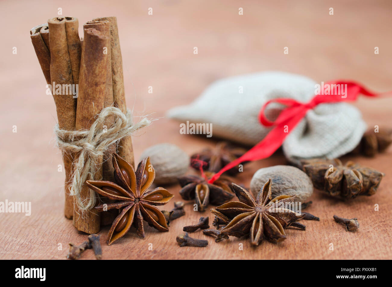 Gewürze für Glühwein. Nahaufnahme von Zimtstangen, Anis Sterne und Nelken auf Holz- Hintergrund. Selektive konzentrieren. Makro mit flachen Freiheitsgrad. Stockfoto