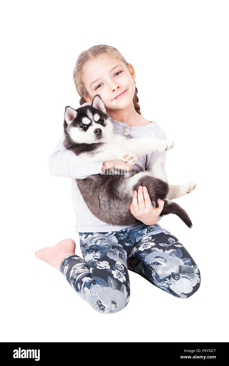 Süße kleine Mädchen umarmt einen Husky Welpe, auf einem weißen Hintergrund. Stockfoto