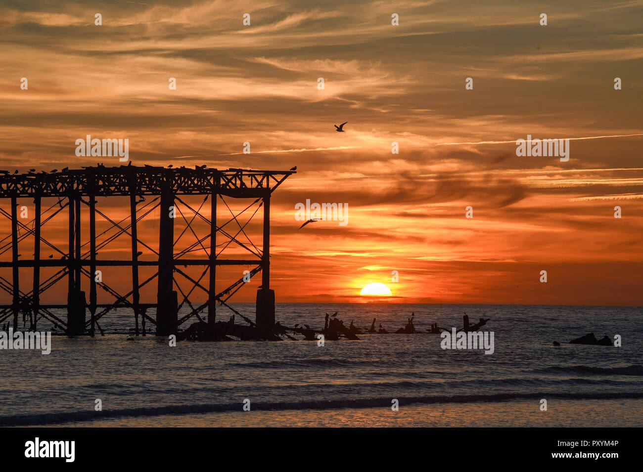 Brighton, UK. 24 Okt, 2018. Die Sonne, die von der West Pier in Brighton an diesem Abend nach der anderen warmen sonnigen Tag an der Südküste: Simon Dack/Alamy leben Nachrichten Stockfoto