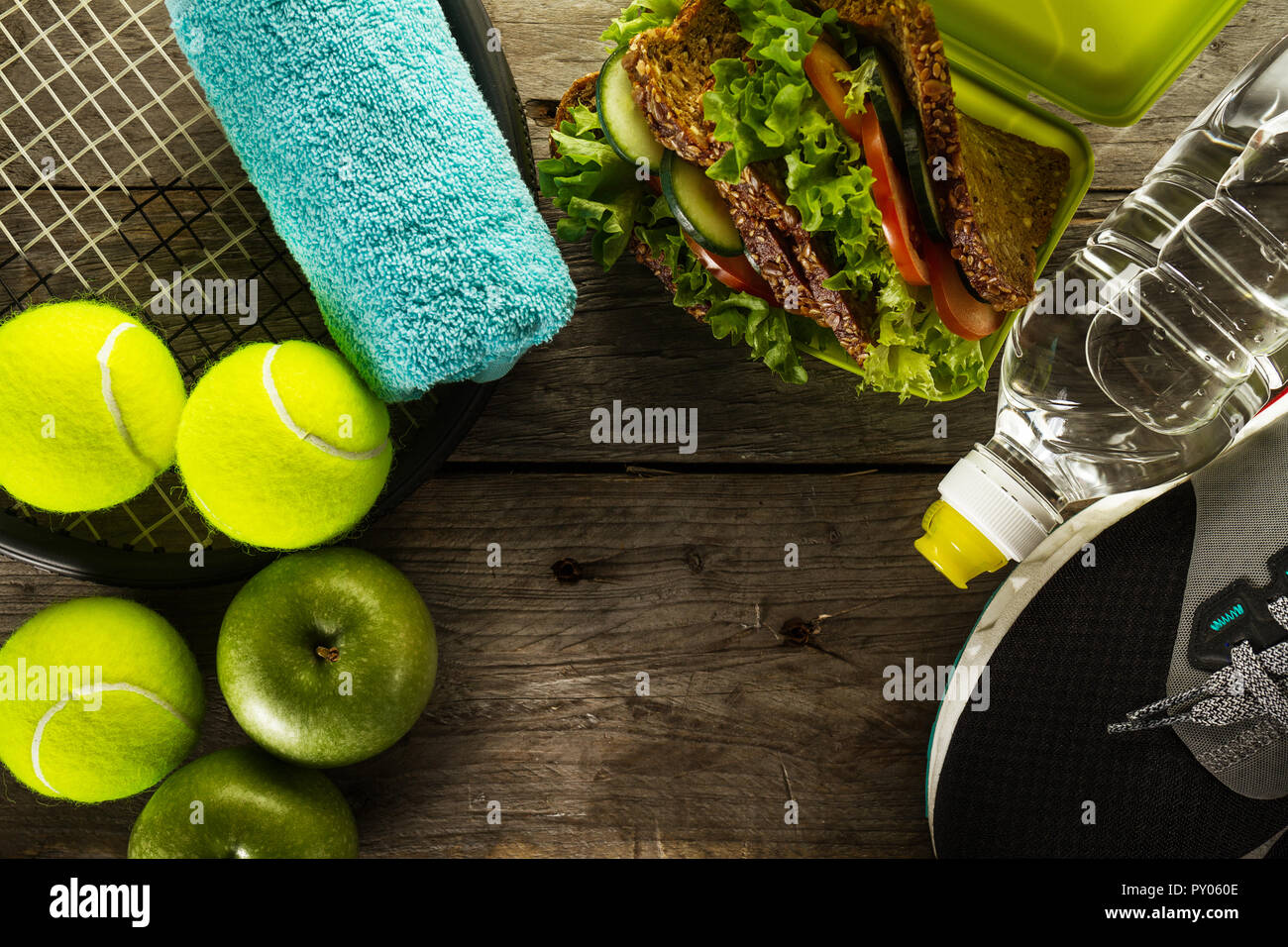 Gesundes Leben Sport Konzept. Sneaker mit Tennisbällen, Handtuch, Äpfel, gesunde Sandwich und eine Flasche Wasser auf Holz- Hintergrund. Kopieren Sie Platz. Oben. Stockfoto