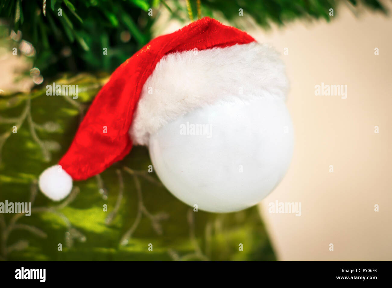 Hängende dekorative weiße Kugel für Weihnachtsbaum mit Red Hat von Santa Claus Stockfoto