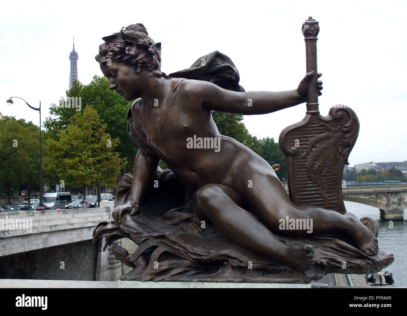 Eine bronze Engel Statue auf eine der Brücken, die Seine im Kreuz. Der Eiffelturm kann im Hintergrund gesehen werden. Stockfoto
