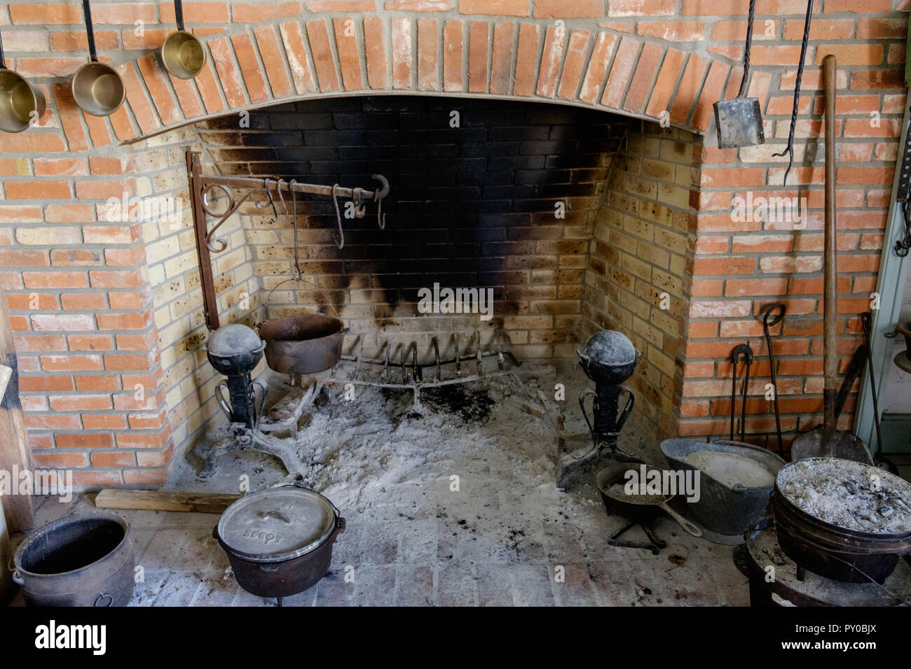 Antike, rustikale Küche Kamin mit alten Kochutensilien. Interieur des Hauses in der Chestnut Square Historic Village, McKinney Texas. Stockfoto