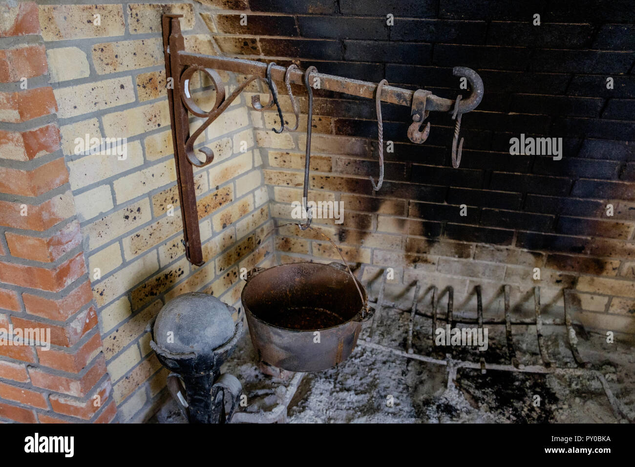 Antike, rustikale Küche Kamin mit alten Kochutensilien. Interieur des Hauses in der Chestnut Square Historic Village, McKinney Texas. Stockfoto