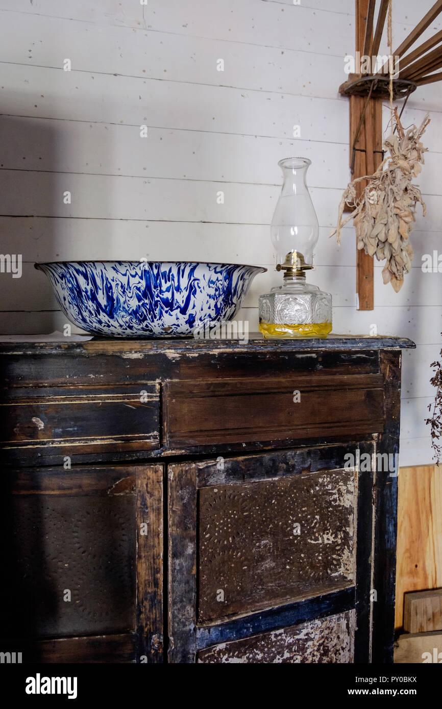 Porzellan blau und weiß Waschbecken & Alte Öllampe auf Holztisch im Inneren des Hauses in der Chestnut Square Historic Village, McKinney Texas. Stockfoto