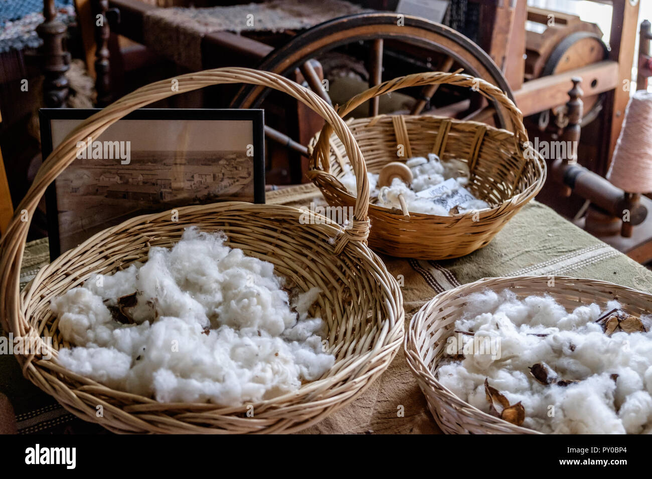 Von Hand gepflückt Baumwolle in Weidenkörbe auf Holztisch im Inneren des Hauses in der Chestnut Square Historic Village, McKinney Texas. Stockfoto