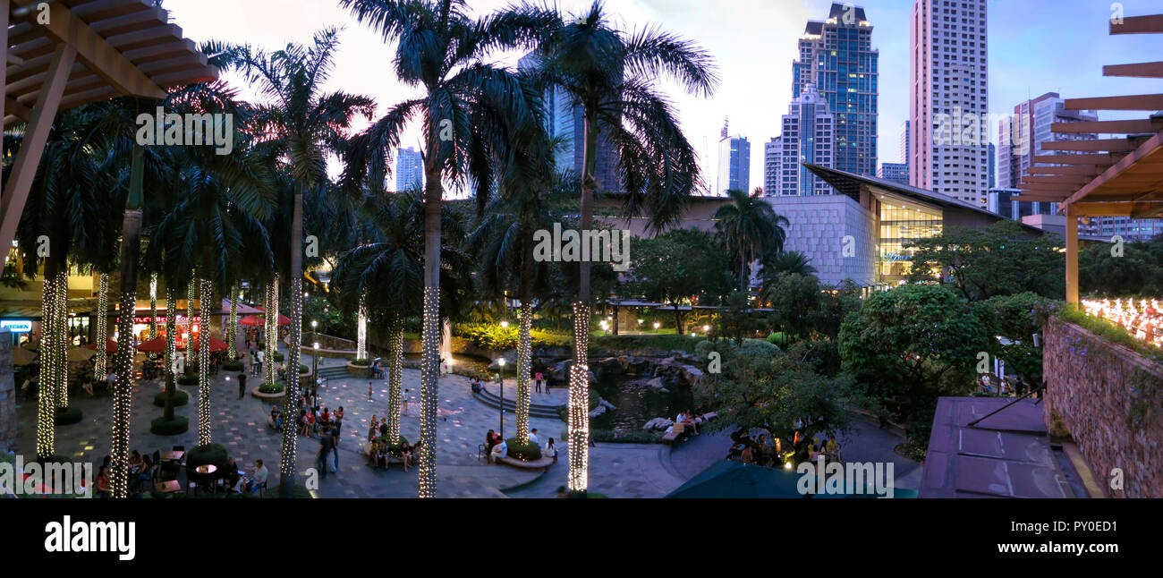 Palmen und Menschen in Greenbelt Park in der Stadt Makati, Philippinen Stockfoto