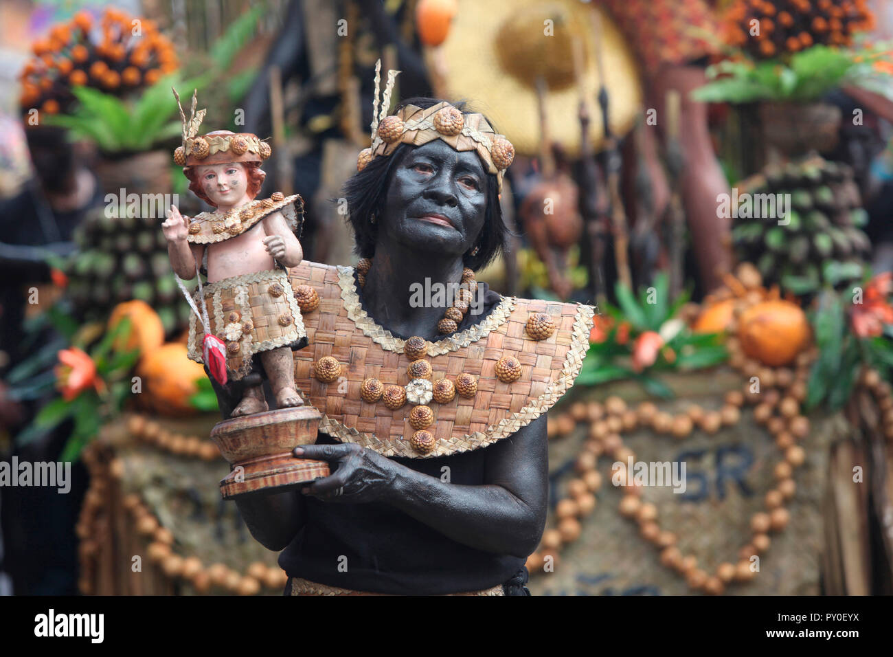 Ältere Frau holding Santo Nino figurine bei Ati Atihan Festival auf unscharfen Hintergrund, Kalibo, Aklan, Panay Island, Philippinen Stockfoto