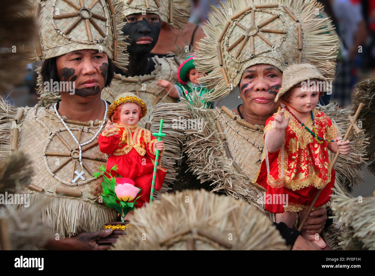 Frauen in tribal Kostüme holding Santo Nino Figuren bei Ati Atihan Festival, Kalibo, Aklan, Panay Island, Philippinen Stockfoto