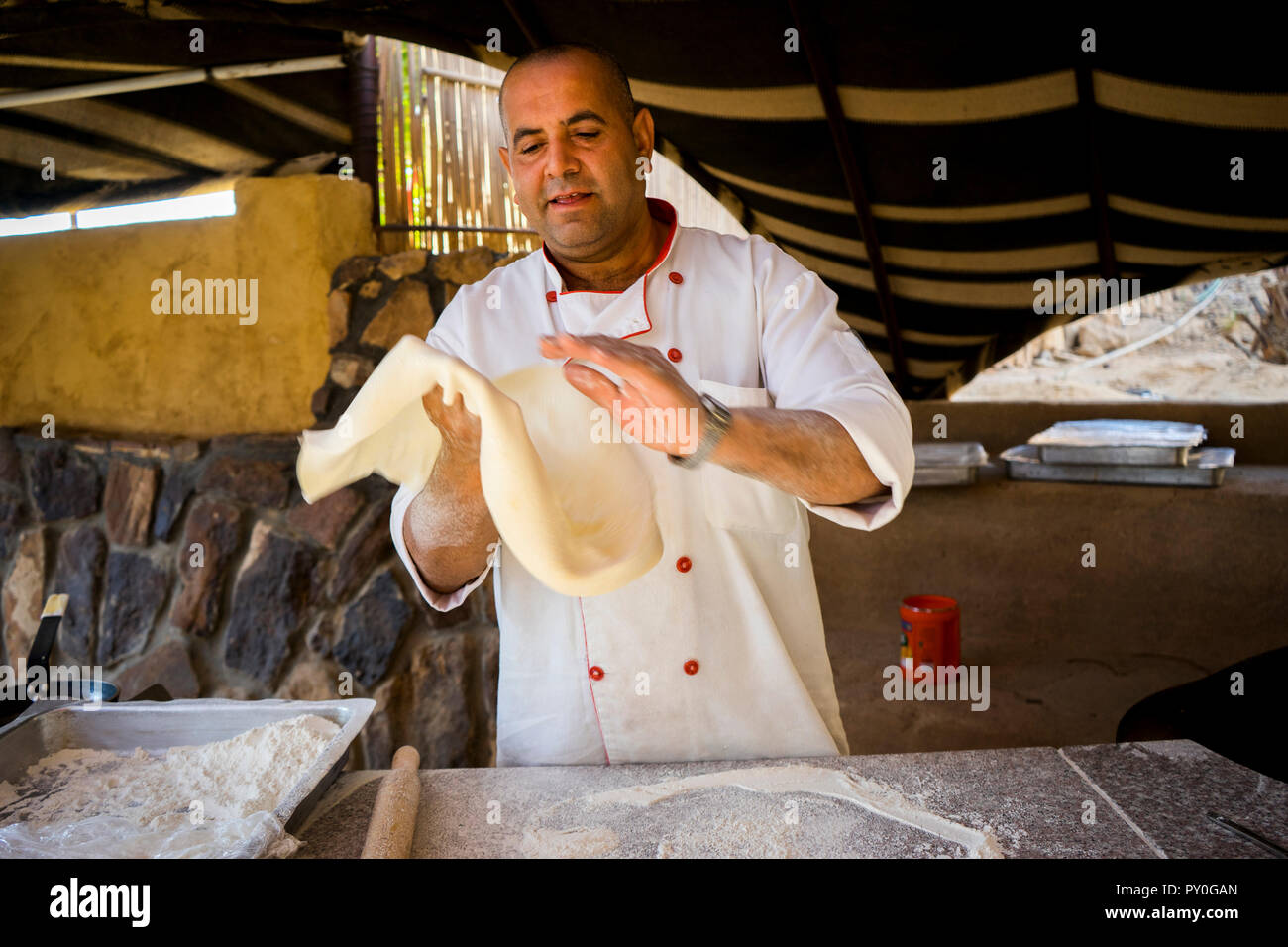Koch warf Brotteig von shrakÂ (markook) machen es sehr dünn vor dem Kochen auf hotÂ sajÂ (orÂ gewölbte ironÂ Grillpfanne), Wadi Rum, Aqaba Governorate, Jordanien Stockfoto