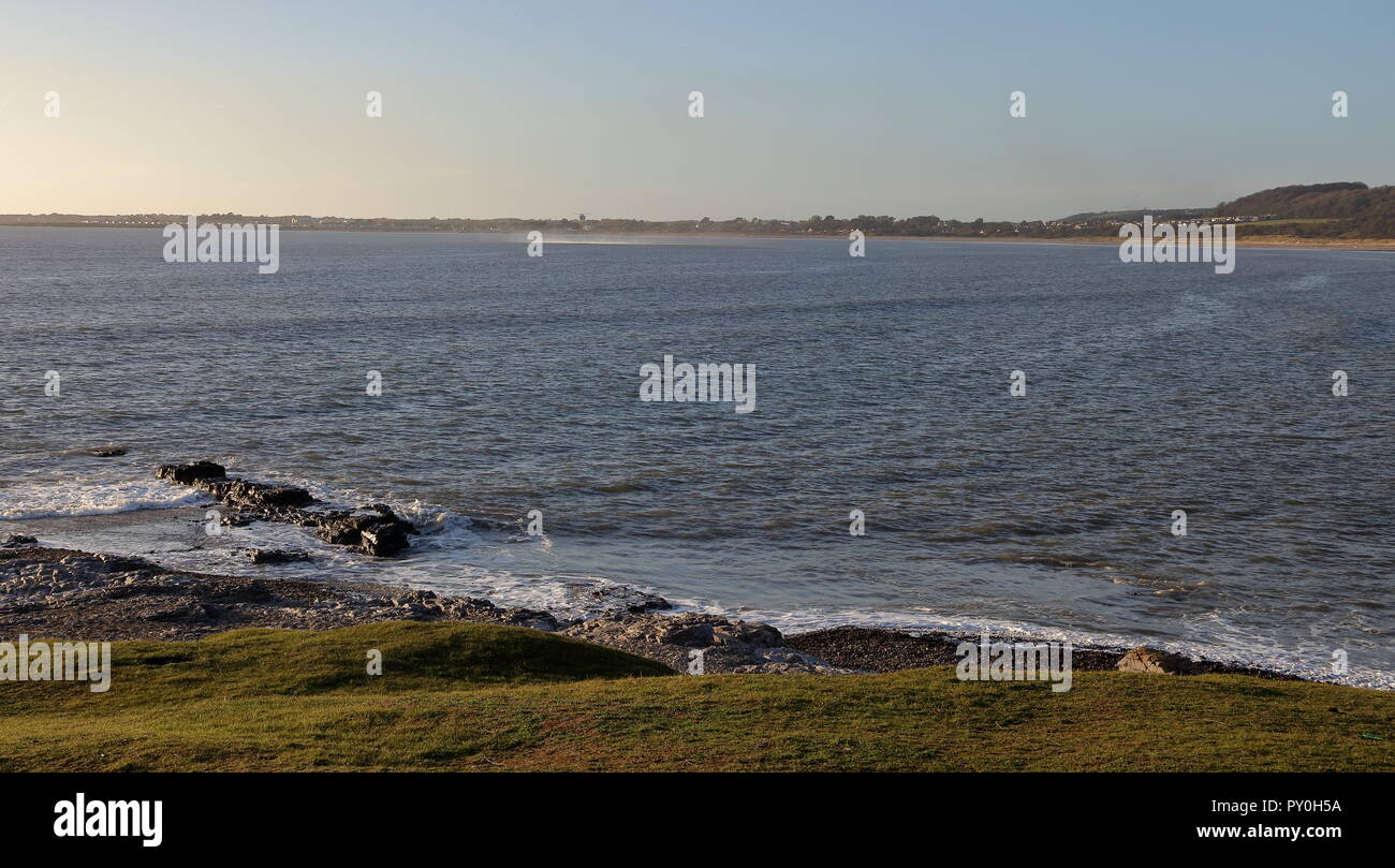 Eine ferne H M Küstenwache Hubschrauber schwebt über dem Meer wartet, bis eine Person im Wasser schwimmenden während einer Training übung in der Bucht zu holen. Stockfoto