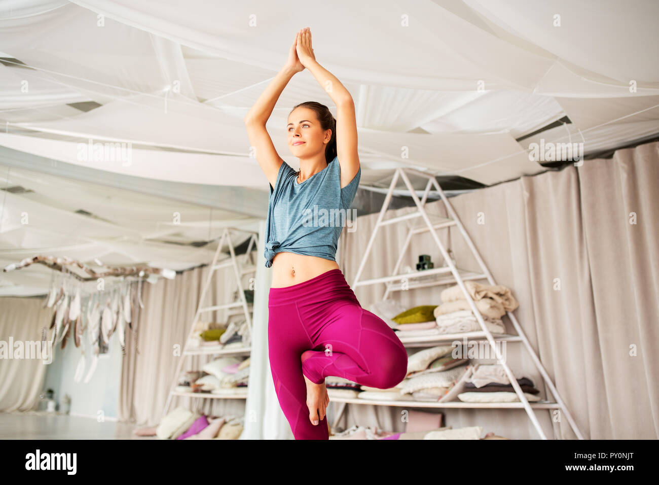 junge Frau tut Yoga-Baum-Pose im studio Stockfoto