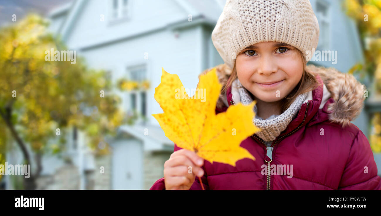 Nahaufnahme der Mädchen mit Herbst maple leaf über Haus Stockfoto