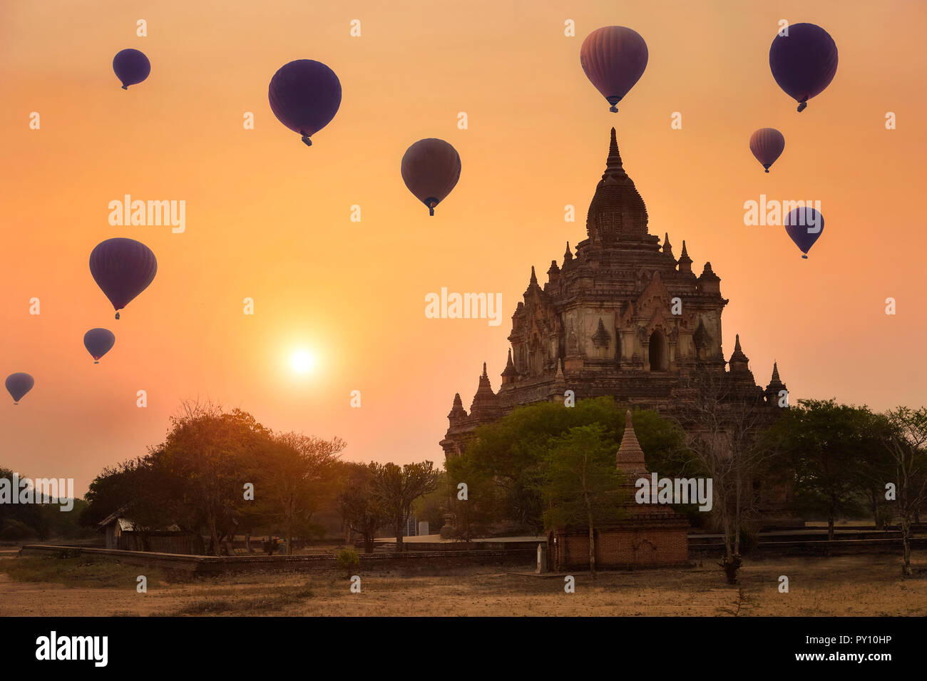 Heißluftballone fliegen über einen Tempel bei Sonnenuntergang, Bagan, Myanmar Stockfoto