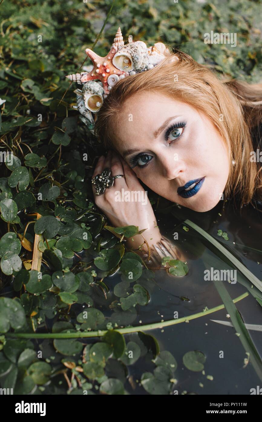 Porträt einer Boho liegende Frau im See, Russland Stockfoto