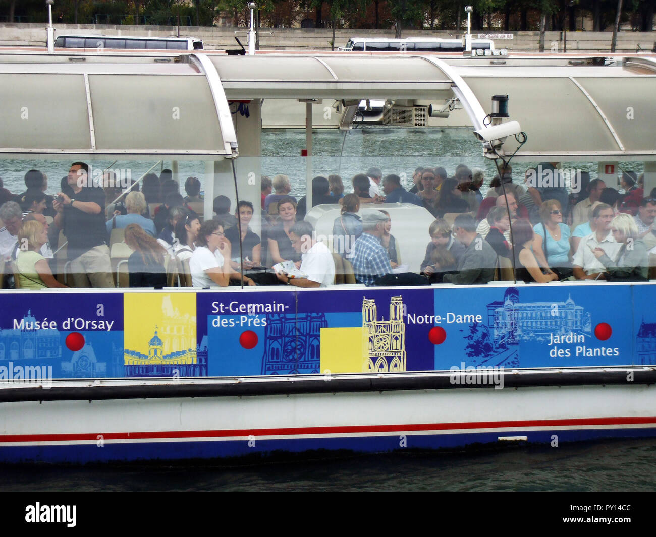 Die Passagiere an Bord eines River Taxi, die Schaulustige und Touristen nach oben und unten durch den Fluss Seine in Paris. Stockfoto