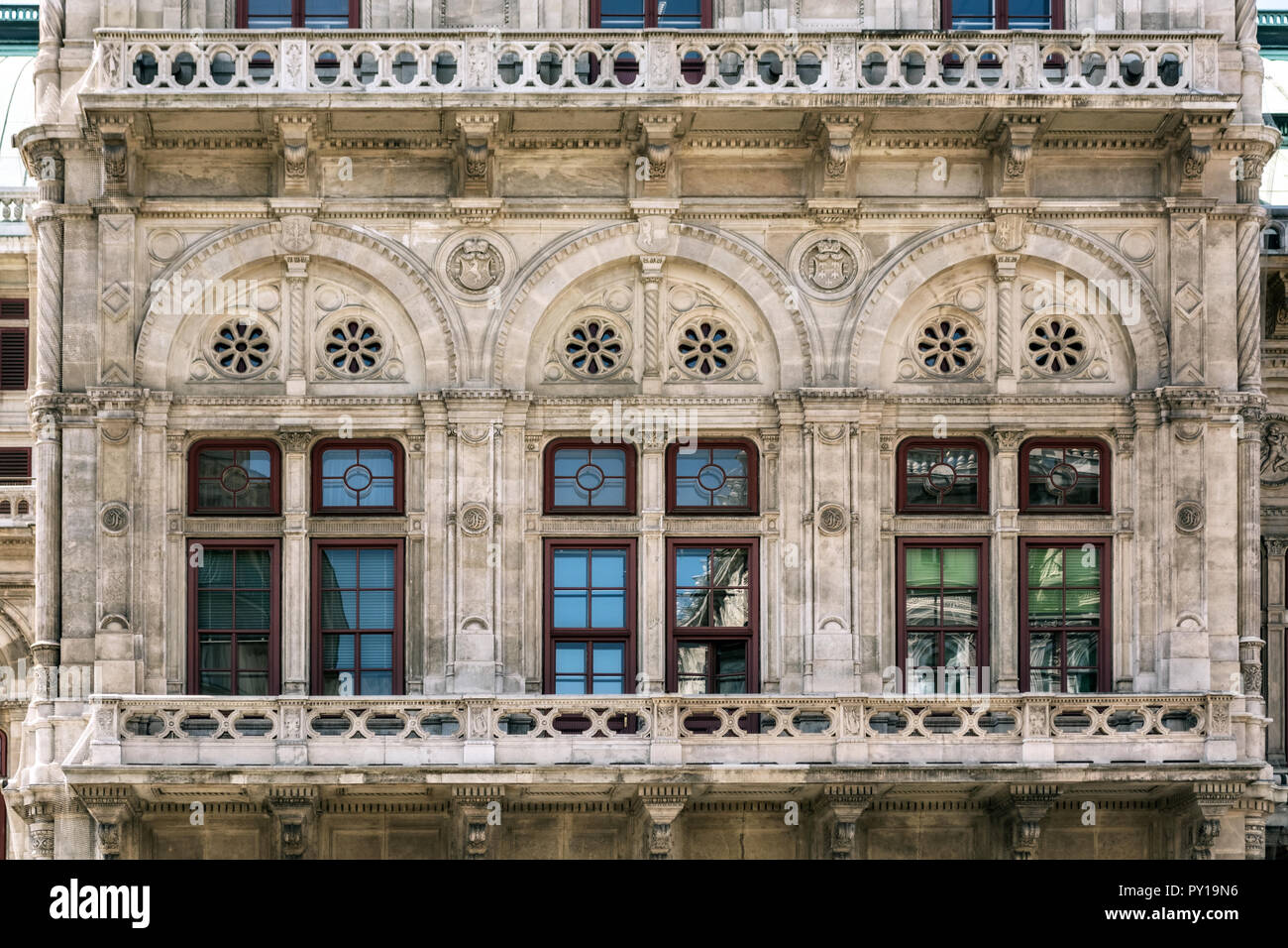 Fenster mit Blick auf den Balkon der Gebäude im gotischen Stil, beige Stein in der Stadt Wien, Österreich. Stockfoto