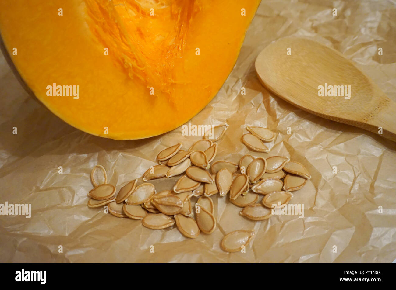 Frische organische und reife Kürbis Slice, Kürbiskerne und Holzlöffel aus Bambus Baum gemacht. Organische und gesundes Kochen Konzept Stockfoto