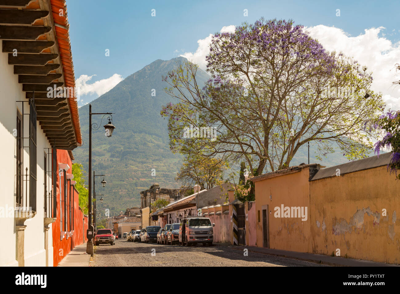 ANTIGUA, GUATEMALA - Februar 24, 2018: Straßenszenen in der beliebten Touristenstadt Antigua, Guatemala mit Volcan de Agua im Hintergrund. Stockfoto