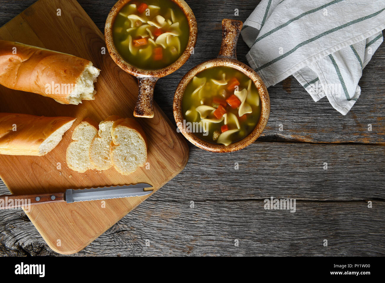 Blick von oben auf die zwei Schalen mit hausgemachten Huhn Nudelsuppe mit frisch gebackenem Brot. Horizontal mit kopieren. Stockfoto