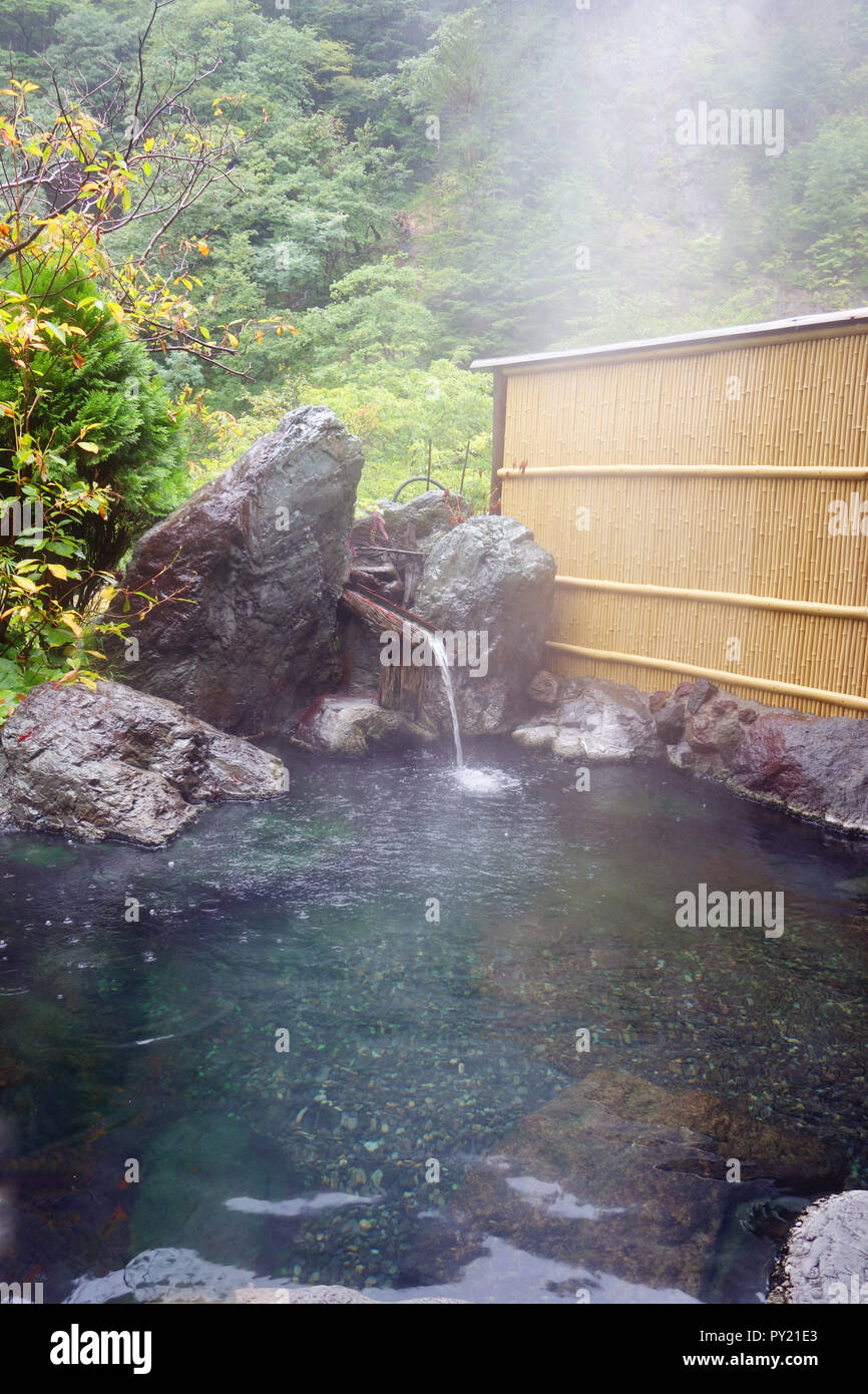 Dampfend heißen Rotenburo (Outdoor Bad) im Regen, sakamaki Onsen Ryokan, Präfektur Nagano, Matsumoto, Honshu, Japan. Keine PR Stockfoto