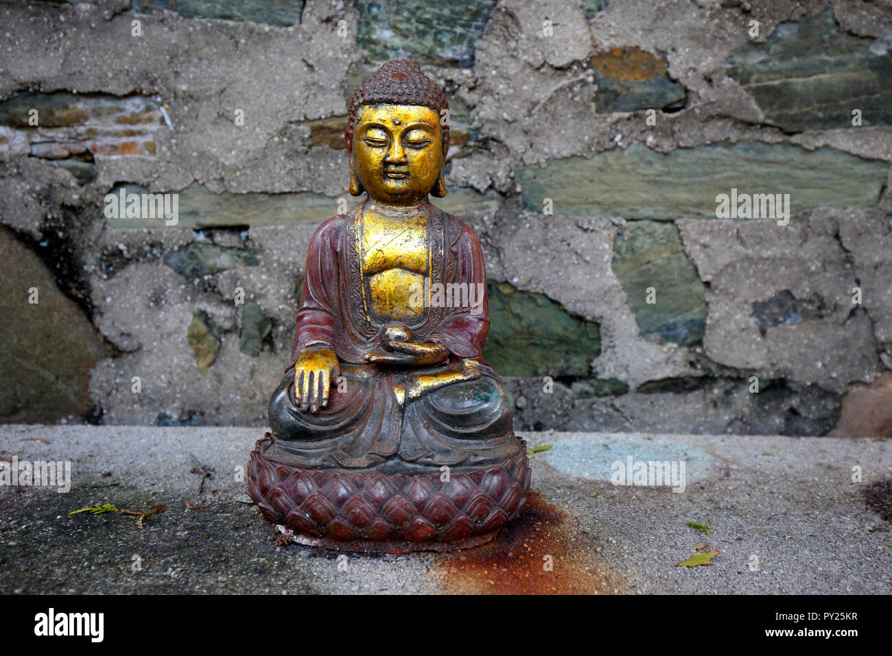 Ein sitzender Buddha Statue auf einer Steinbank am Jacques Marchais Museum der tibetischen Kunst Stockfoto