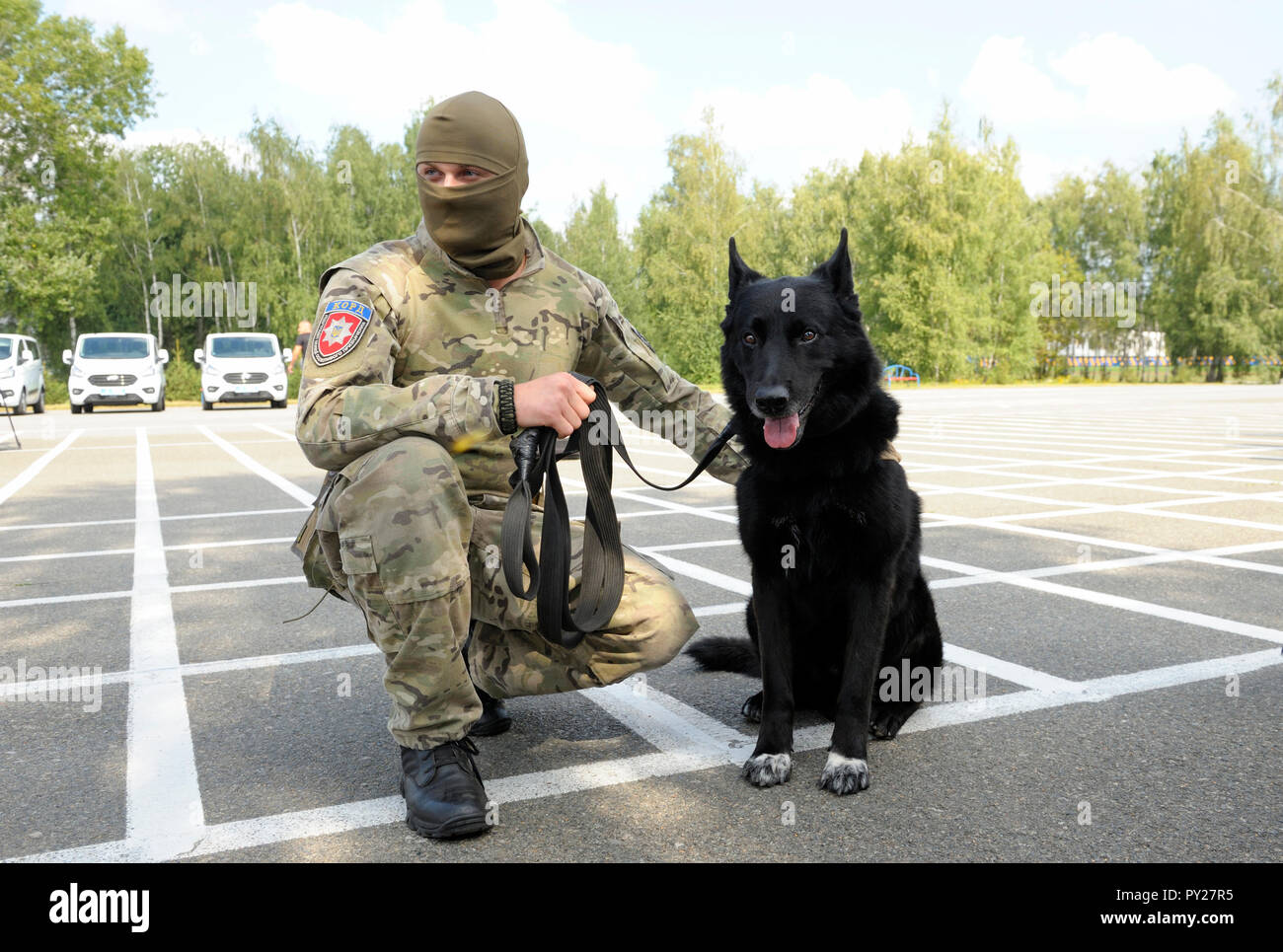 Soldat des KORD Einheit (Ukrainisch SWAT) in Uniform und seine Polizei Hund sitzt auf einem Boden. September 5, 2018. Kiew, Ukraine Stockfoto