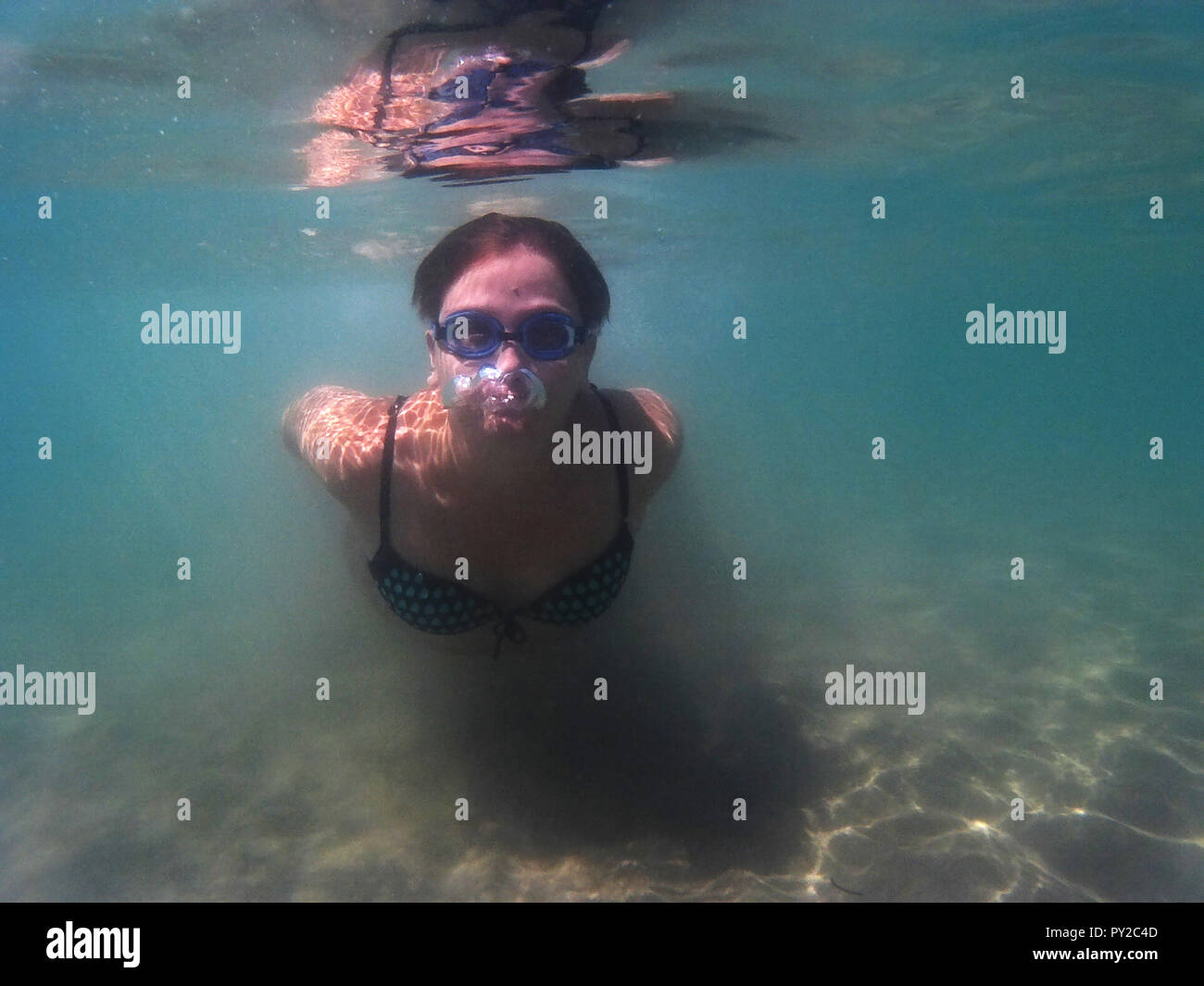 Frau Schwimmen unter Wasser im Meer, Apulien, Italien Stockfoto