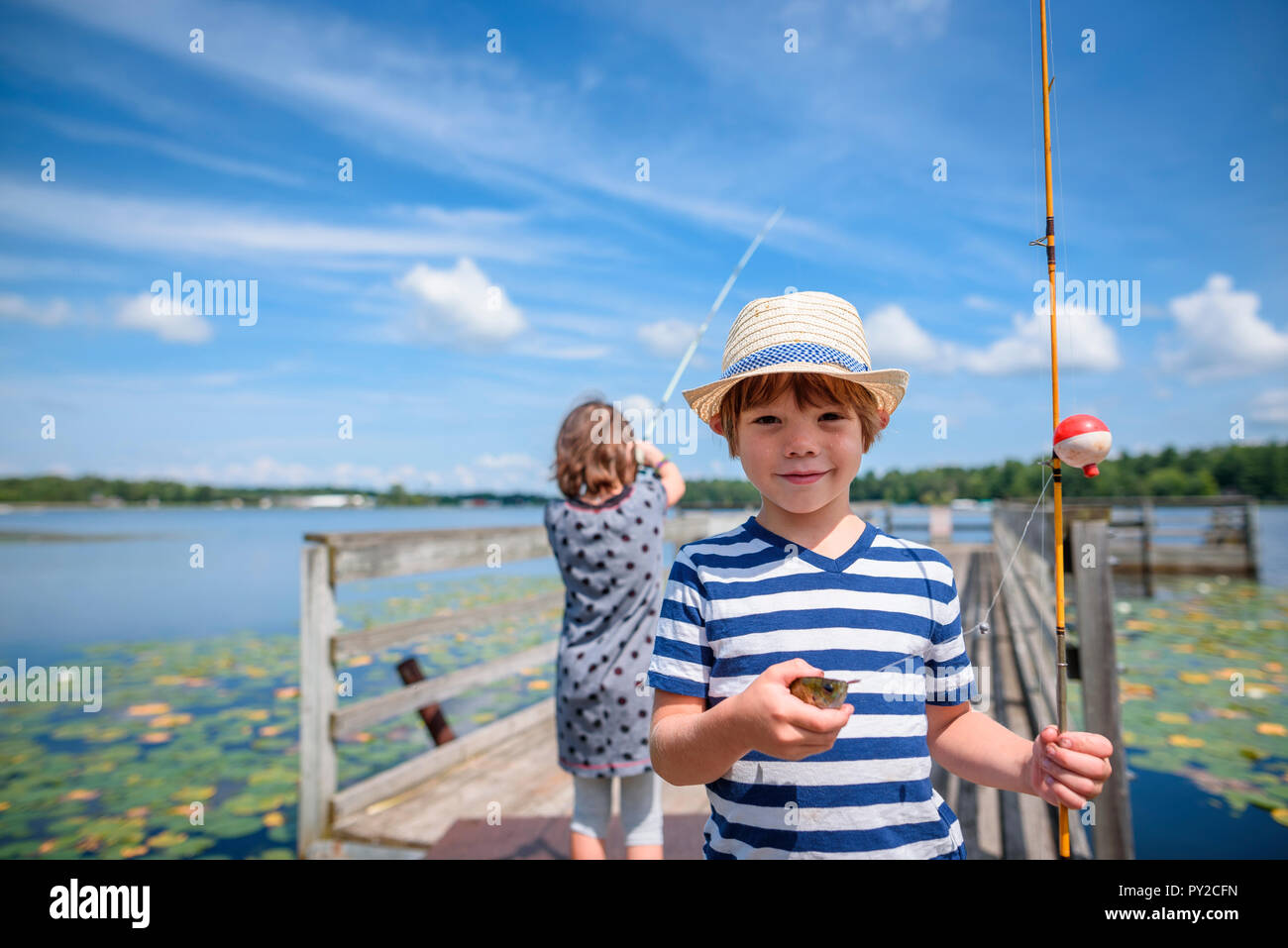 Zwei Kinder Angeln auf einem Dock im Sommer, United States Stockfoto