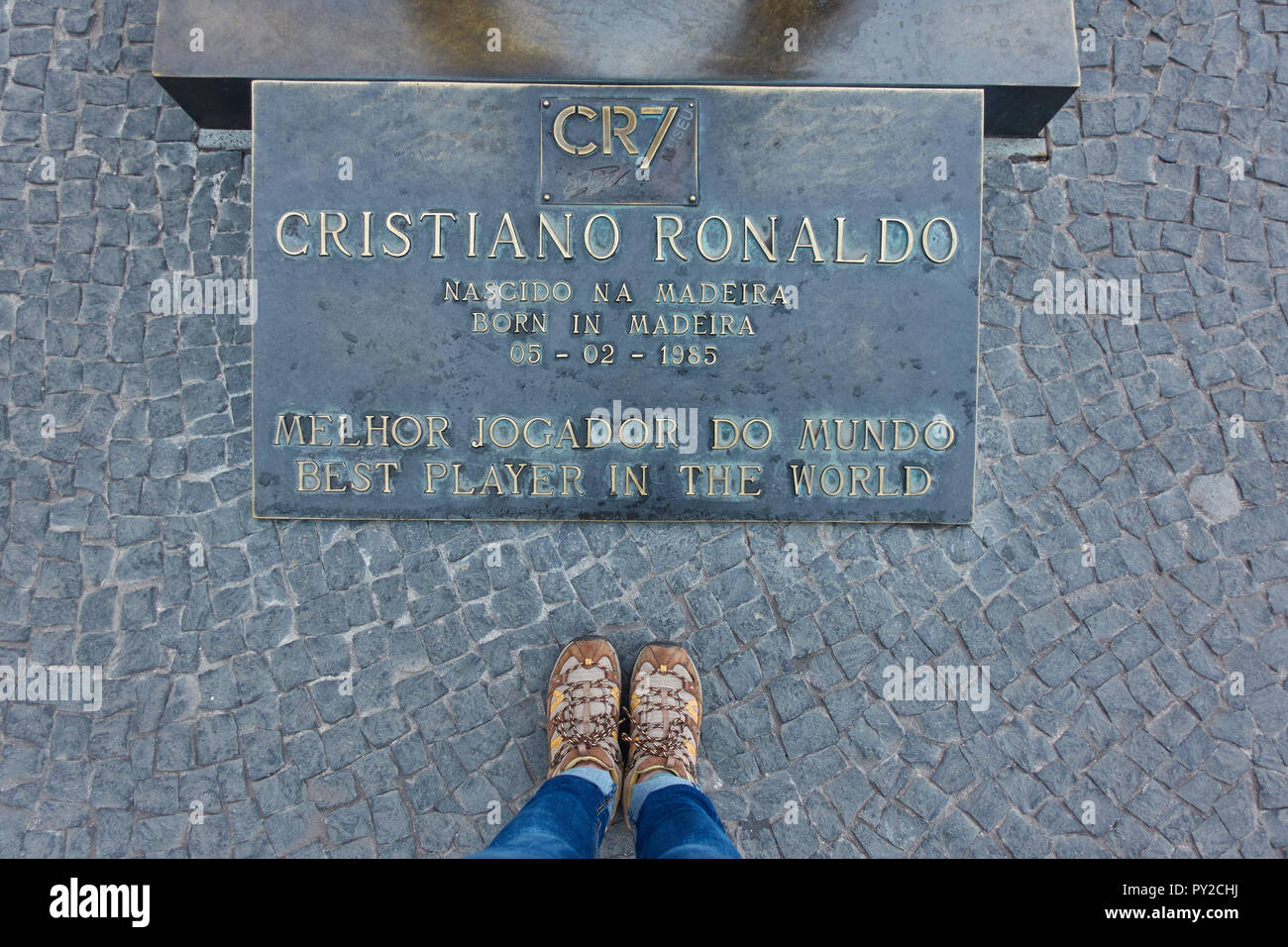 Frau mit ihren Schuhen in der Nähe von CR7 Cristiano Ronaldo statue Plakette in CR7 Stockfoto