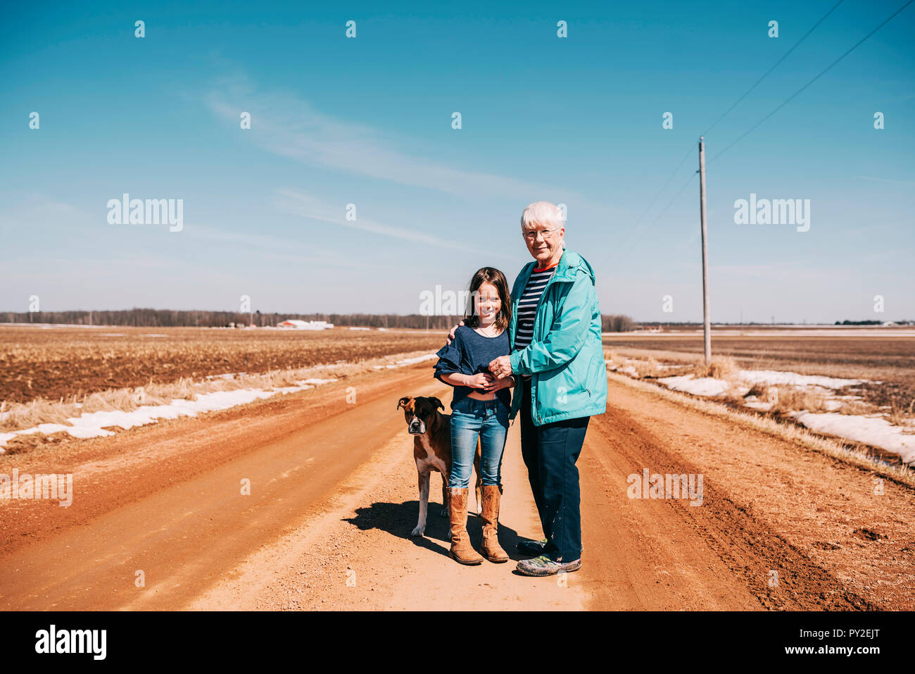 Großmutter und Enkelin auf der Straße mit ihrem Hund stehend, United States Stockfoto