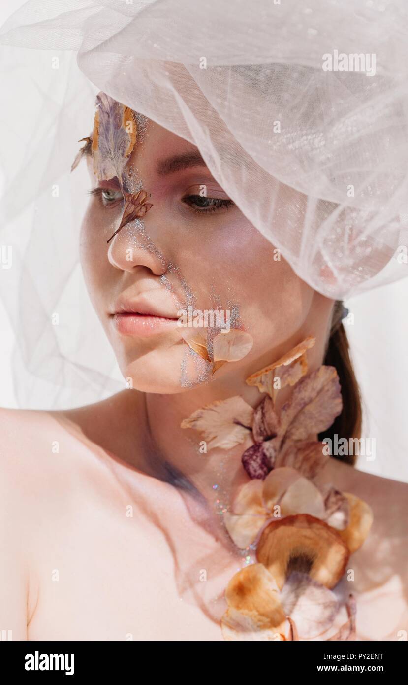 Konzeptionelle beauty portrait einer Frau mit Kopftuch mit getrockneten Blumen auf ihr Gesicht und Hals Stockfoto