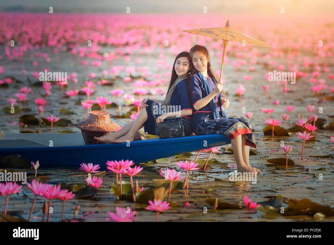 Zwei Frauen sitzen auf einem Boot in einem Lotus Lake, Thailand Stockfoto