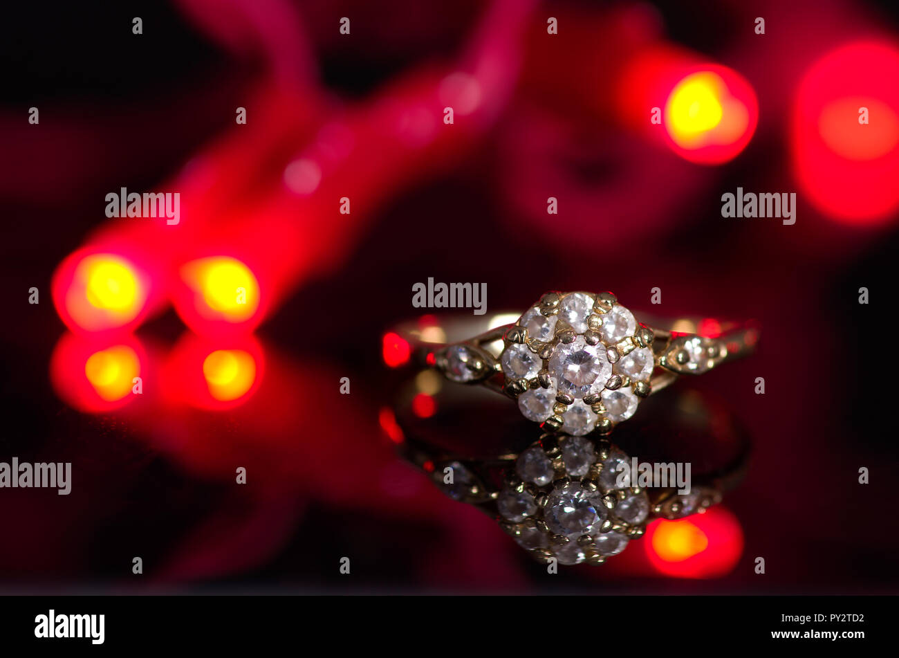 Einen goldenen Ring auf einem schwarzen Hintergrund im Licht der roten Leuchten. Stockfoto