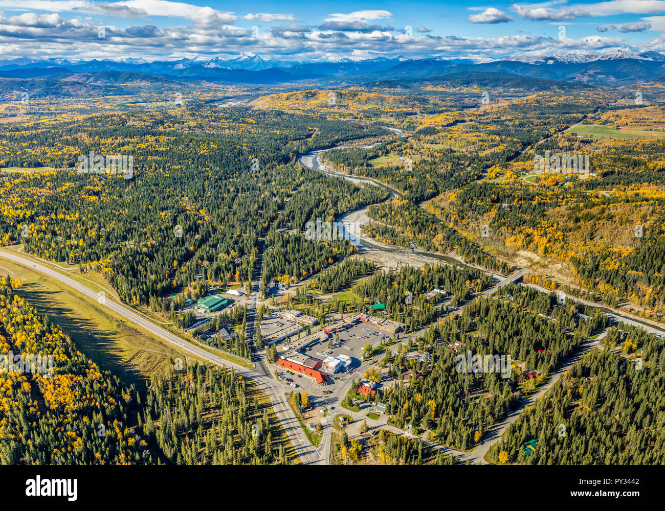 Luftaufnahme des Weilers Bragg Creek, Alberta mit Elbow River und Rocky Mountains im Hintergrund. Stockfoto