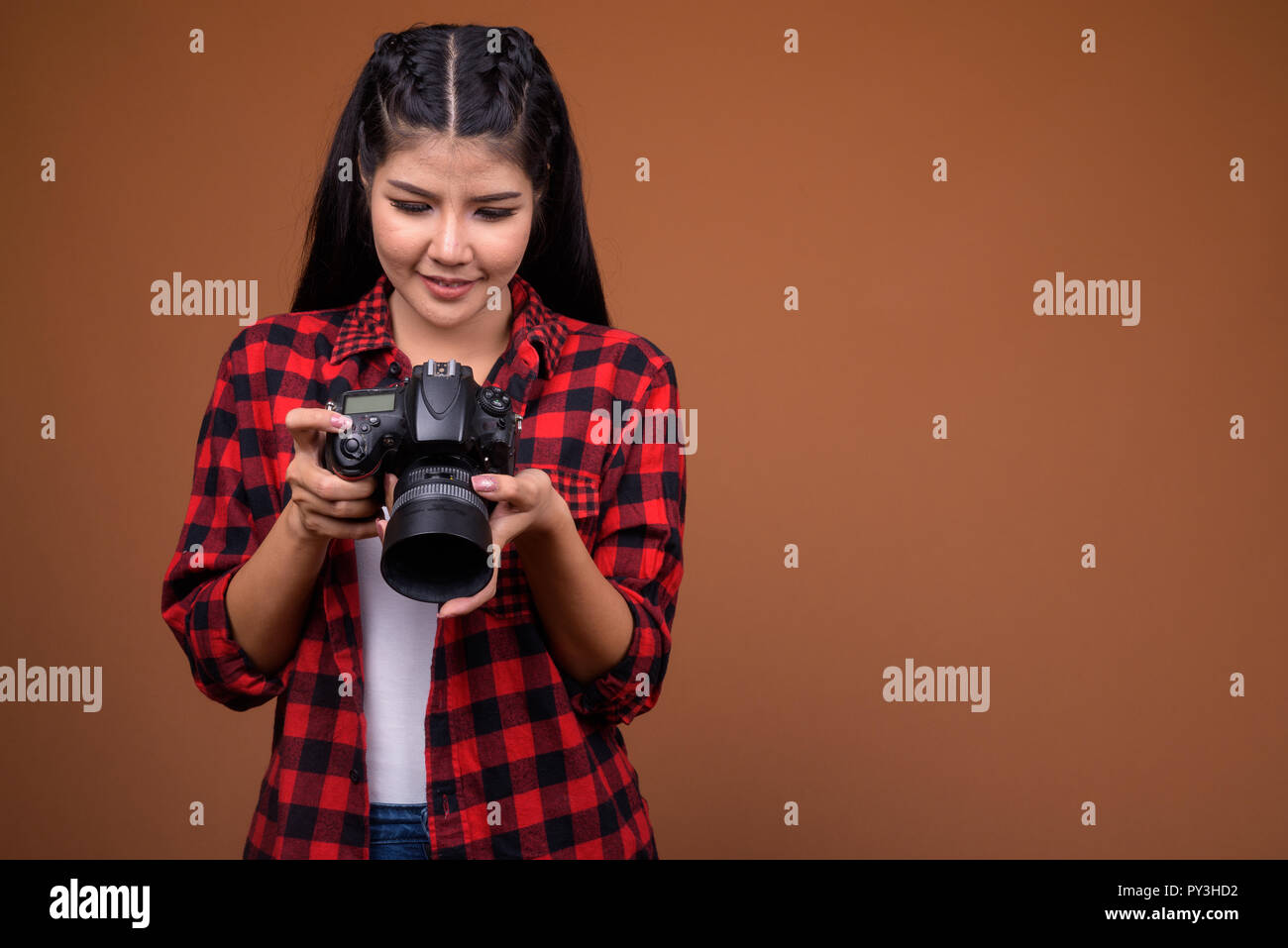 Junge schöne asiatische Frau Fotograf holding Kamera Stockfoto