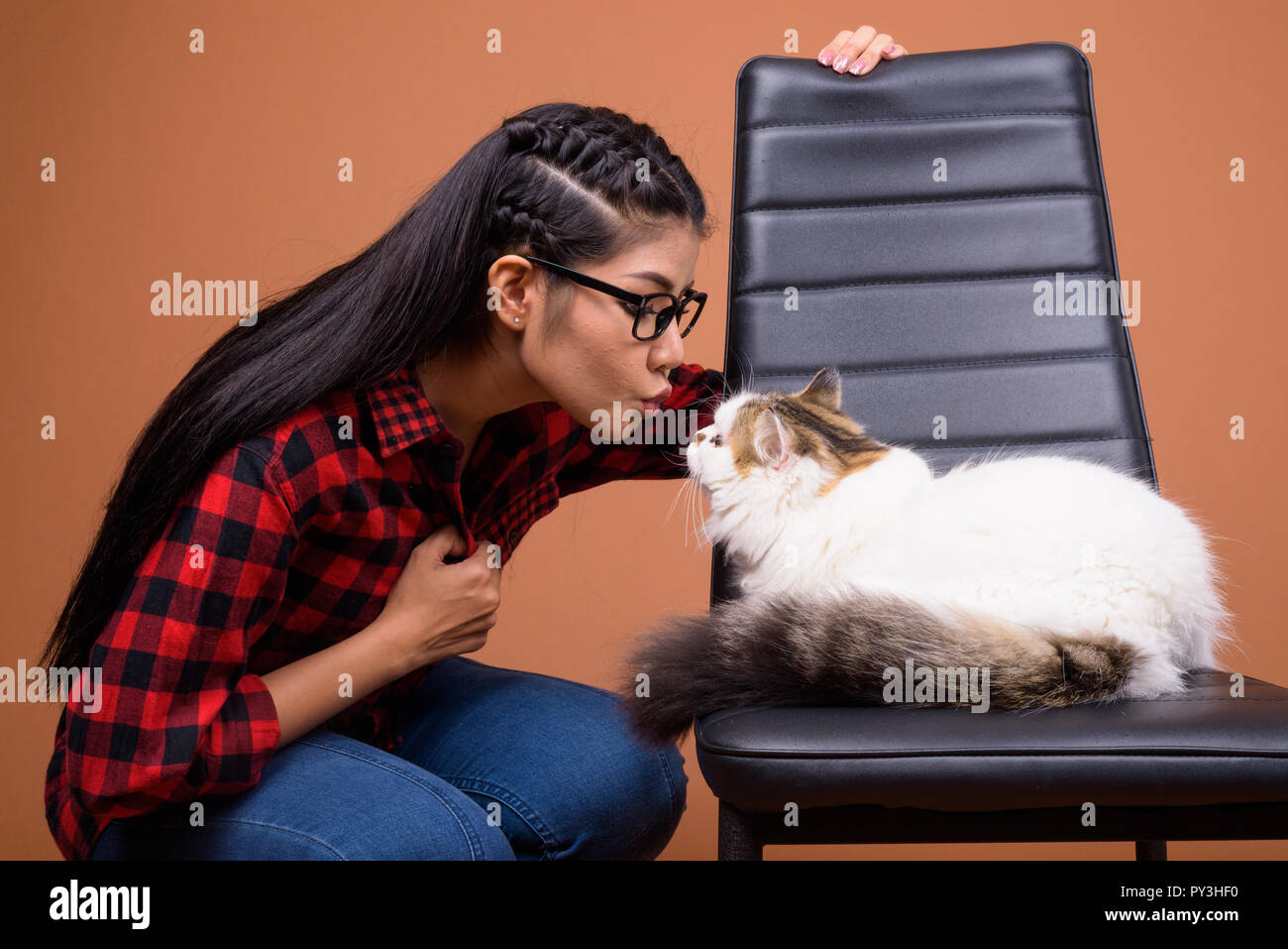 Junge schöne asiatische Frau mit Persischen Katze Stockfoto