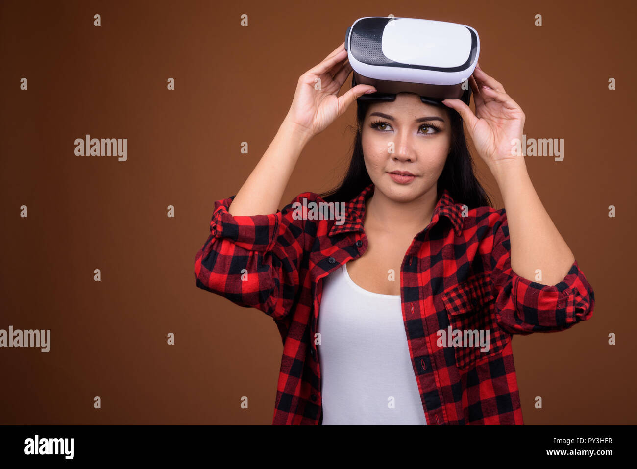 Asiatische Frau mit VR-Brille für die virtuelle Realität beim Denken Stockfoto
